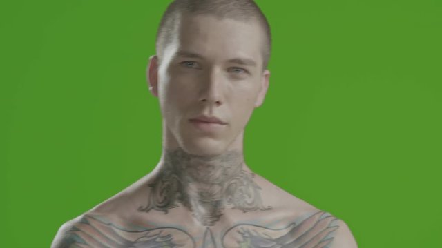Handsome sexy young man stylish with tattoo on his neck, torso and hand - middle shot portrait studio - greenscreen Prores - cinematic lighting