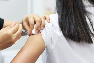 Vaccination for women in vaccine room.Doctor hand is holding needle for women vaccine. Medical...
