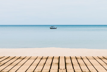 Wooden terrace with sand beach and bule sea ,Fisherman fishing on the boat background