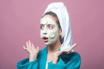 Woman with cucumber mask on surprised face on violet background