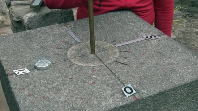 Equator line stone landmark with indicators of compass North South West East. The middle of the world. Galapagos.