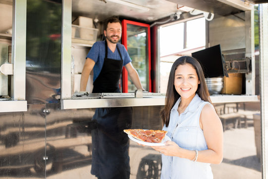 Woman buying pizza from a food truck