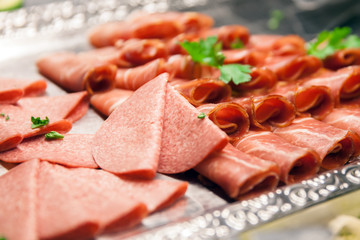 A slices of sausage on big silver plate