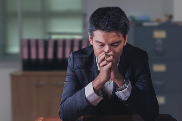 Handsome young businessman praying for success  in office,business office concept