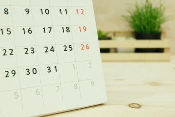 calendar placed on wooden table has ornamental plants in wood basket are background. image for business, object, decorated, equipment, education concept