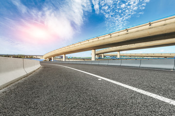 Asphalt road and highway bridge under the blue sky