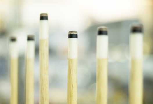 Billiard cues on the rack. Billiard game equipment. Wooden cues for table game.