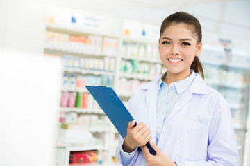 Asian female pharmacist working in chemist shop or pharmacy