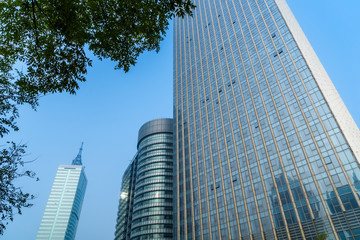 Obraz premium view of contemporary glass building with green leaves, china.