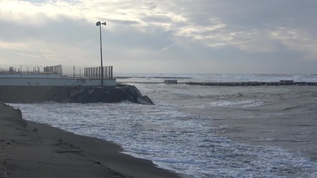 Waves rolling on the beach is a stormy day, winter mediterranean sea. Focene, Lazio, Italy. 4k