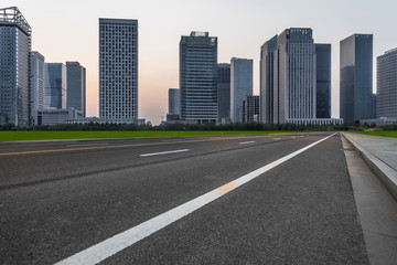 Fototapeta na wymiar clean asphalt road through modern city skyline