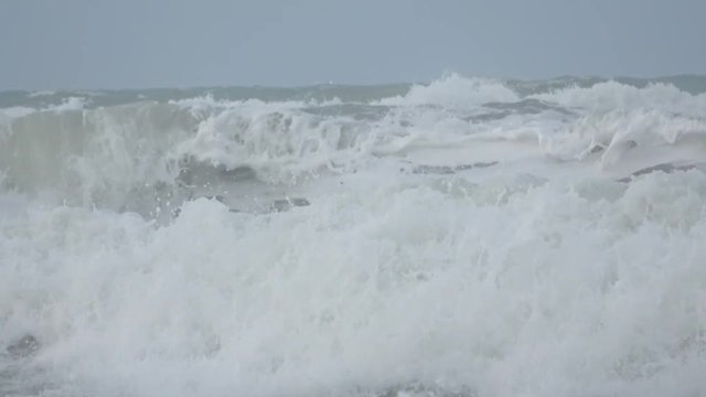Waves rolling on the beach is a stormy day, winter mediterranean sea. Focene, Lazio, Italy. 4k