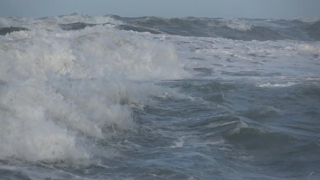 Waves rolling on the beach is a stormy day, winter mediterranean sea. Focene, Lazio, Italy. Slow motion