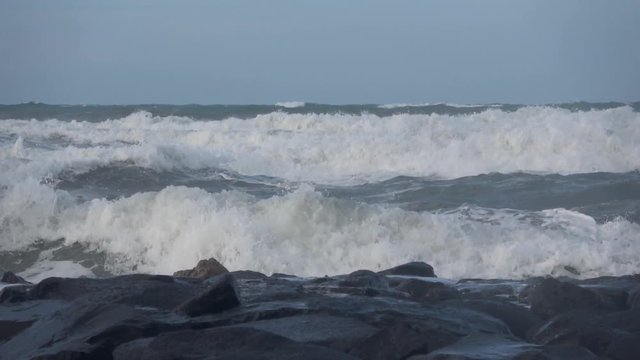 Waves rolling on the beach is a stormy day, winter mediterranean sea. Focene, Lazio, Italy. Slow motion