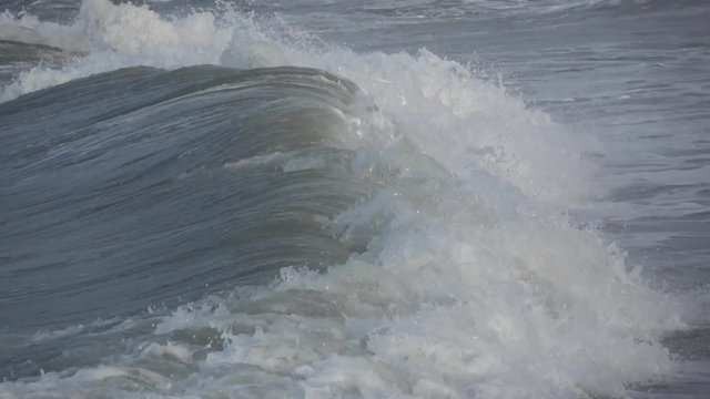 Waves rolling on the beach is a stormy day, winter mediterranean sea. Focene, Lazio, Italy. Slow motion