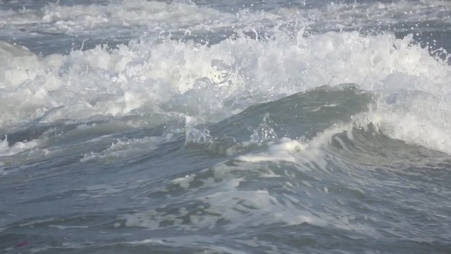 Waves rolling on the beach is a stormy day, winter mediterranean sea. Focene, Lazio, Italy. Slow motion