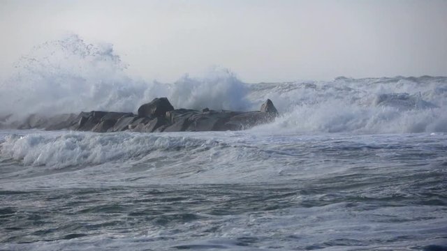 Waves rolling on the beach is a stormy day, winter mediterranean sea. Focene, Lazio, Italy. Slow motion