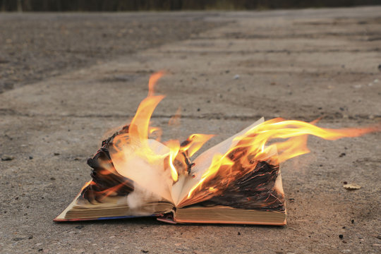 book with burning pages on a concrete surface