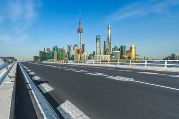 Fototapeta na wymiar road through the bridge with shanghai city skyline background