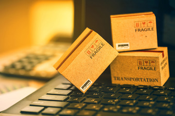 Light brown three small boxes on a laptop keyboard. An idea of transportation that can be done...