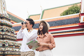 Asian couple tourists visiting Thai temple in Bangkok  Thailand on summer holidays