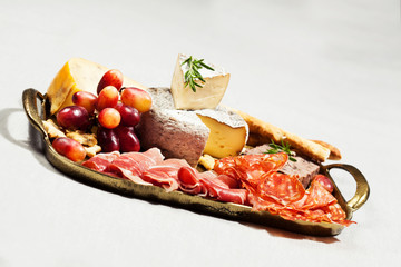 Food tray with charcuterie assortment, cheese  and grapes