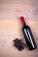 Bottle of wine on rustic wooden background, copy space, top view, vertical. Red wine