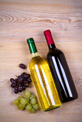 Bottle of wine on rustic wooden background, copy space, top view, vertical. Red and white wine