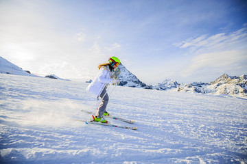 Fototapeta na wymiar Girl on skiing on snow on a sunny day in the mountains. Ski in winter seasonon, the tops of snowy mountains in sunny day. South Tirol, Solda in Italy.