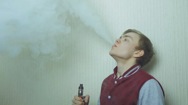 Young man smoking electronic cigarette. Young Man Using Vapourizer As Smoking Alternative