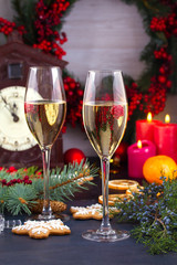 Champagne glasses in holiday setting. Christmas and New Year celebration with champagne. Christmas holiday decorated table with white sparkling wine, vertical