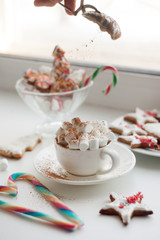 Hot chocolate with marshmallow, candy cane in shape of heart, new year morning sweetness close up