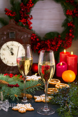Champagne glasses in holiday setting. Christmas and New Year celebration with champagne. Christmas holiday decorated table with white sparkling wine, vertical