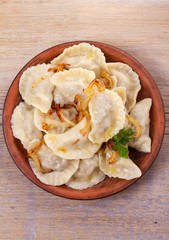 Dumplings, filled with meat and served with salty caramelized onion. Varenyky, vareniki, pierogi, pyrohy. Dumplings with filling. View from above, top studio shot, vertical