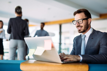 Young handsome architect working on laptop in office
