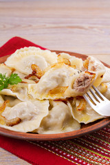 Dumplings, filled with meat and served with salty caramelized onion. Varenyky, vareniki, pierogi, pyrohy. Dumplings with filling, vertical