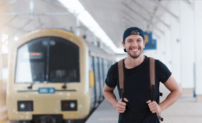 Young traveler walking with backpack on train staition and waiting train