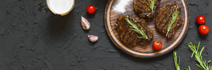 Appetizing beef steaks, beer and rosemary
