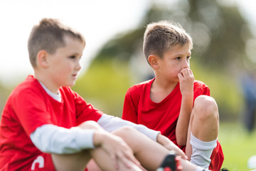 Young children players football match on soccer field - boys watching game