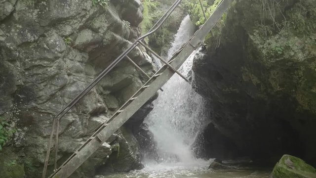 Slow motion view of waterfall through ledder bridge