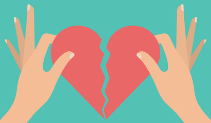 Woman's hand tearing apart a red heart