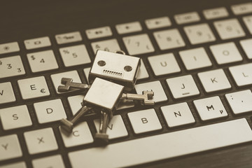 Roboter auf Tastatur, Methapher für Chatbot / Socialbot, Algorithmen und künstliche Intelligenz