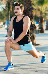 Male athlete stretching legs after strength training