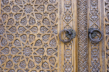 Fototapeta na wymiar An old wood door with metal handle. Details of Muslim architecture.