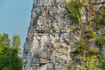 Beautiful rocky summer landscape. Climber on the rocks of Twardowski at the lagoon of Zakrzowek in Krakow, Poland.