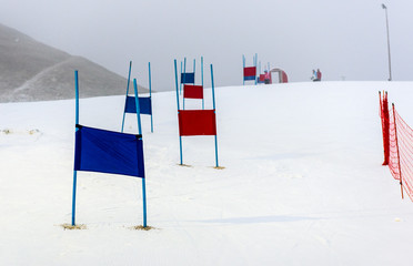 Children skiing slalom racing track with blue and red gates.