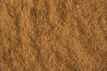 ground nutmeg powder spice as a background, natural seasoning texture - obrazy, fototapety, plakaty