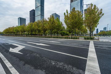 empty road and modern office block buildings against sky, china.