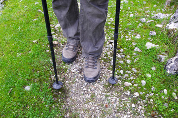 Woman hiking in mountains, adventure and exercising. Legs and nordic walking poles