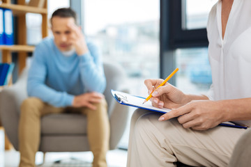 Preliminary diagnosis. Selective focus of psychologist notes being written during a psychological session